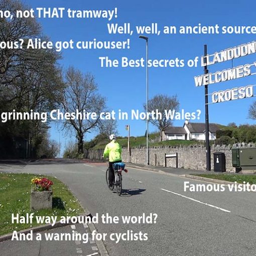 Cyclist passes the Welcome to Llandudno sign